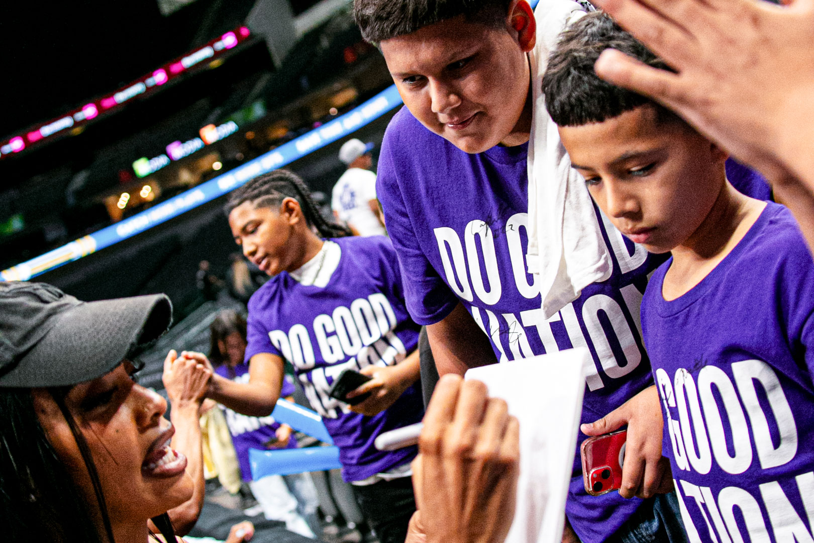 Kids down at the rail getting their Do Good Nation shirts signed after the game