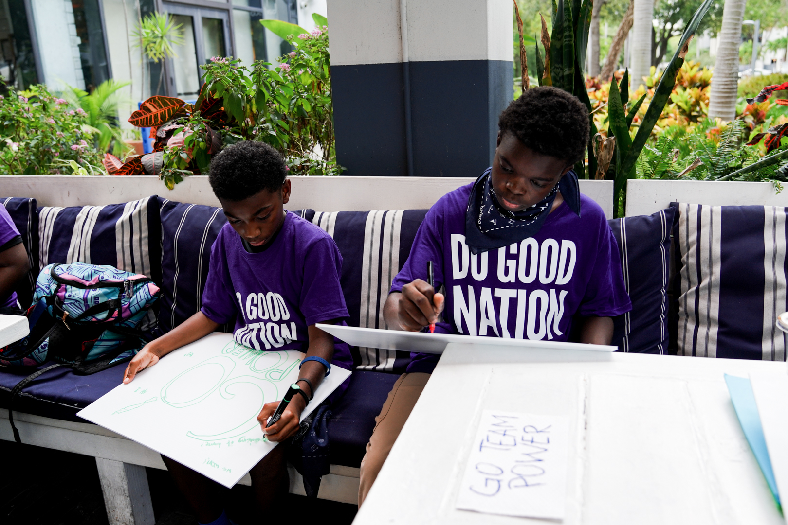 Two kids drawing their own game day signs before heading to the arena